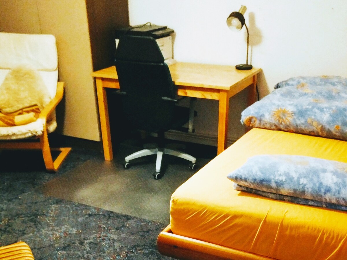 Spálňa s dvoma lôžkami a stolom.