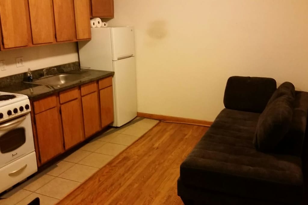 Full kitchen with fridge, stove,microwave, dishes, utensils, and sofa/bed
