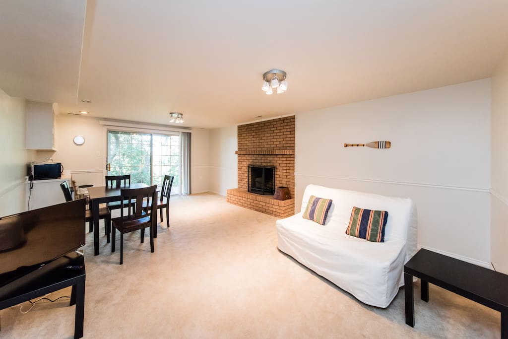 living room with flat screen TV, sofa bed with bed mattress, small frig and microwave, coffee maker.
