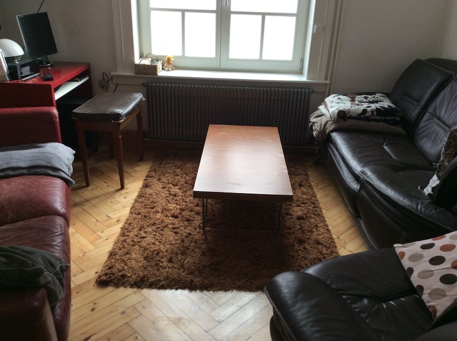 Petit salon avec deux canapés et un fauteuil