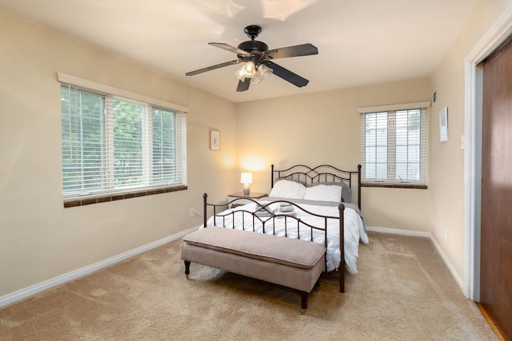 Cette chambre spacieuse est complète avec un lit confortable, un banc pour la détente et deux fenêtres pour la lumière naturelle.