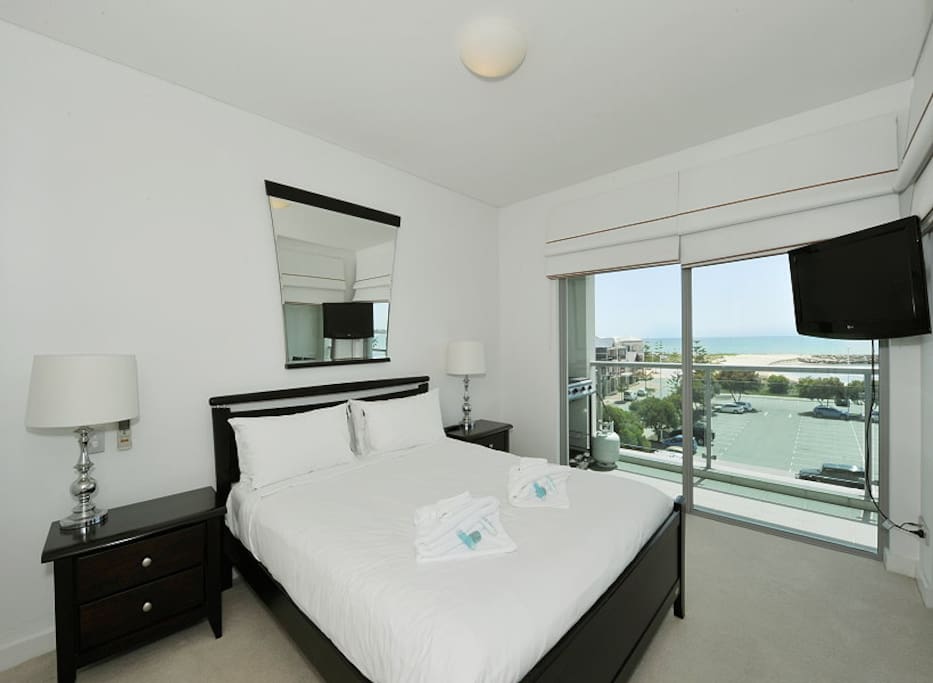 Main Bedroom with queen size bed overlooking the ocean. The main bedroom has it's own Television.