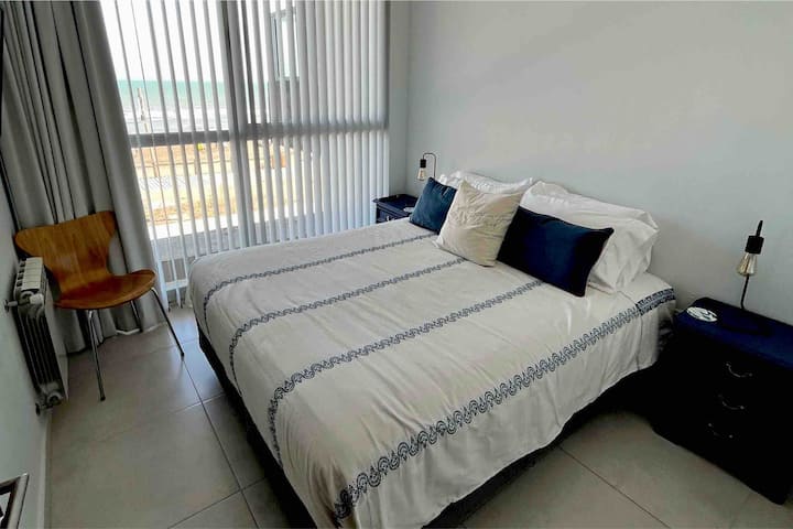 Მთავარი საძინებელი ოკეანის ხედის დიდი ფანჯრით. Queen ‑ ის ზომის საწოლი სიმონსის ბრენდის ყუთით. Placard