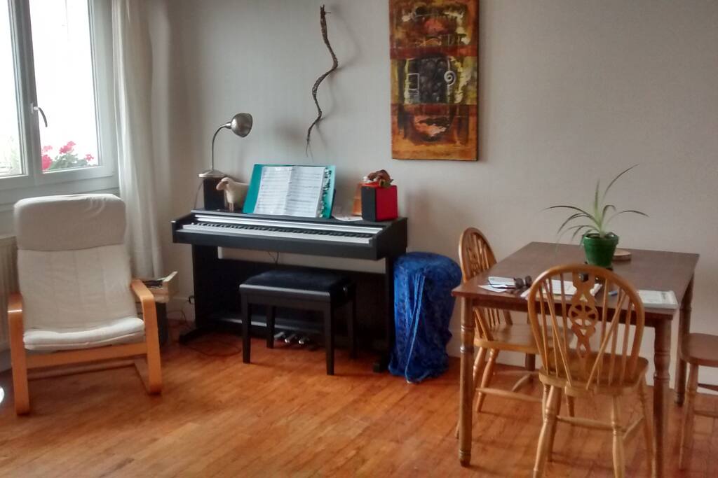 Petit salon / salle à manger avec piano et balcon