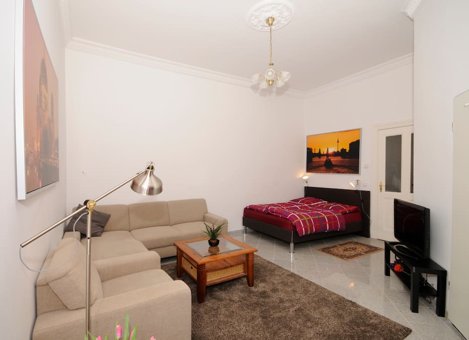 large cozy room with double boxspring bed, sofa, fridge, tv, free wifi