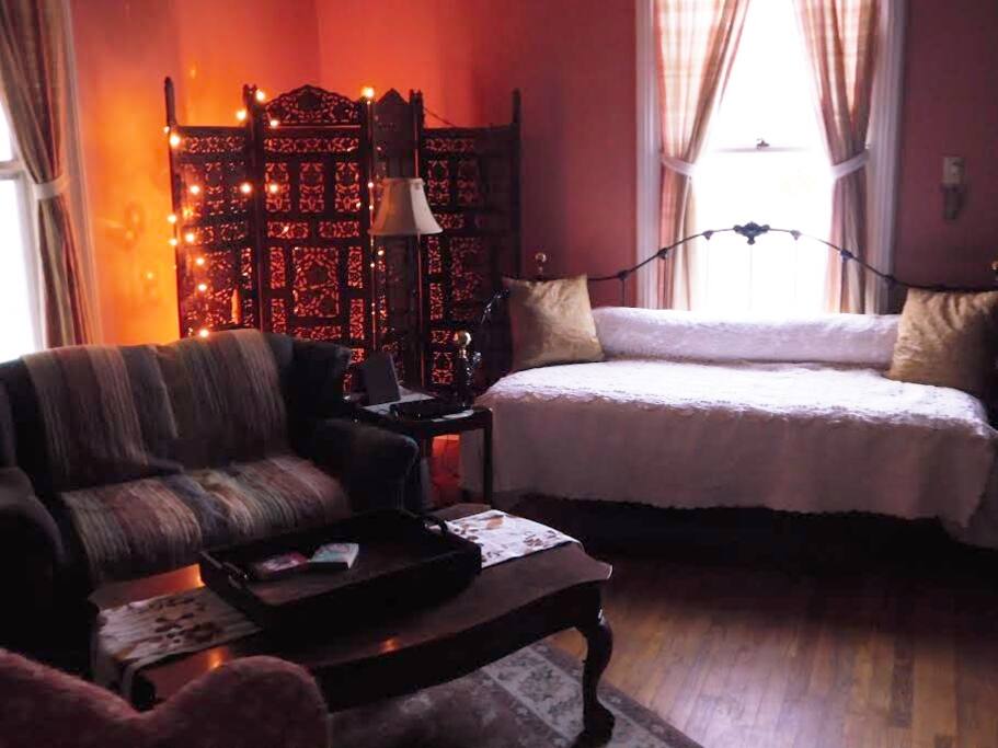 This is the living room area of the room which also includes a single bed, pictured here at the window. I am standing in the doorway that leads to the loft area to take this pic.