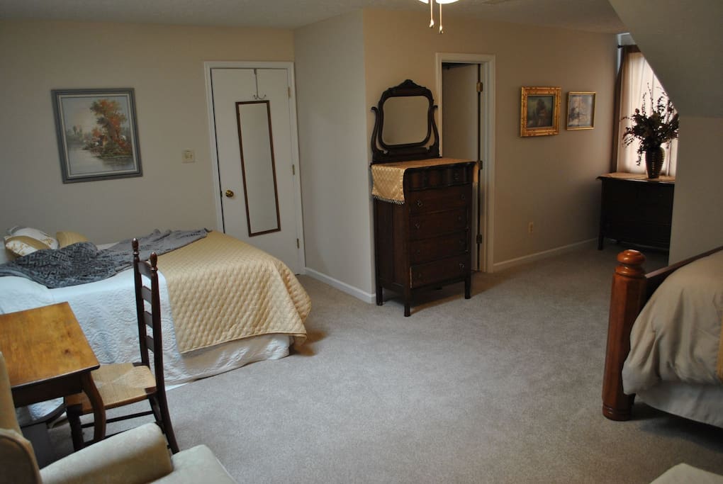 The on-suite is to the right of the chest of drawers.
