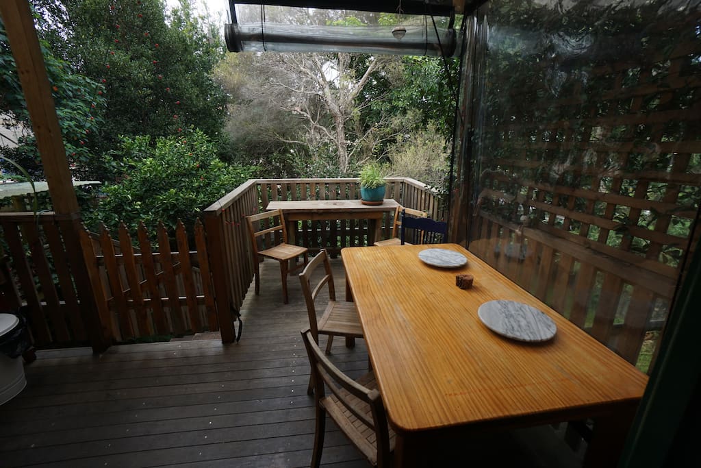 Double leadlight doors lead to shared outside covered deck overlooking leafy back garden.