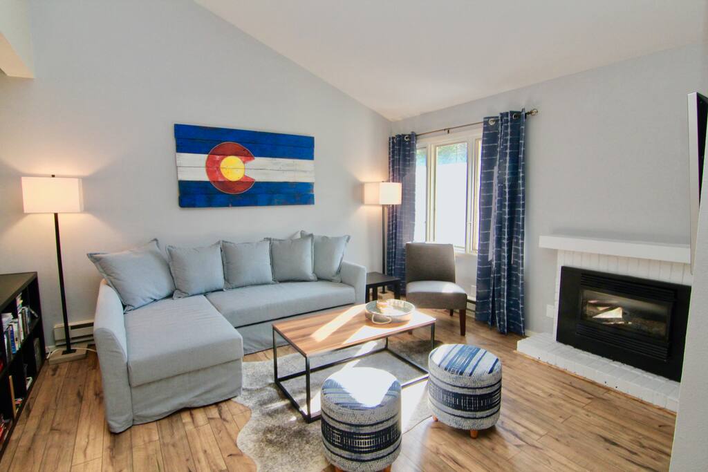 Living room with plenty of seating a gas fireplace, and large TV accross from the couch.