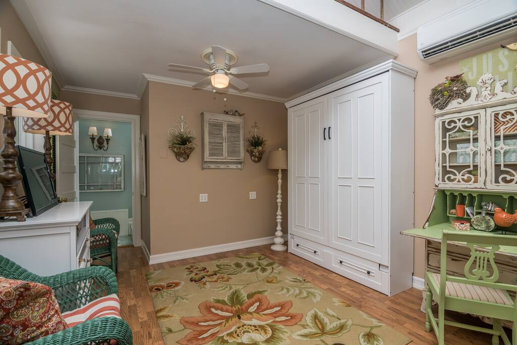 View of Living Area with Queen Wall Bed Cabinet Closed and Hand Painted Secretary with Matching Chair