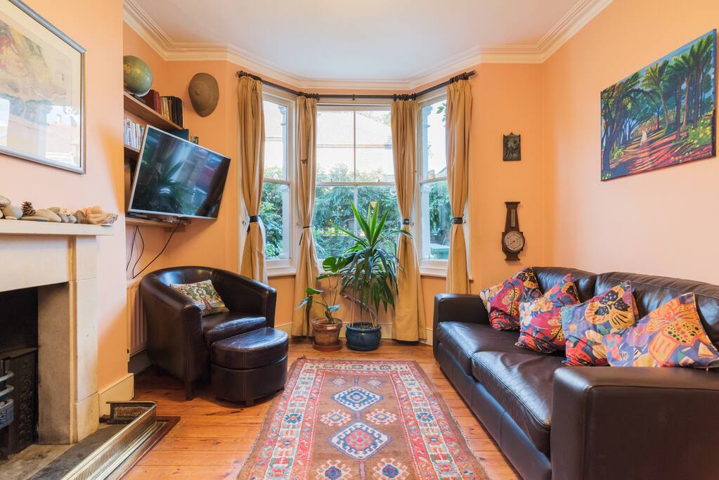 The comfortable living space at Greenhill Towers, with large flatscreen TV and open fireplace.