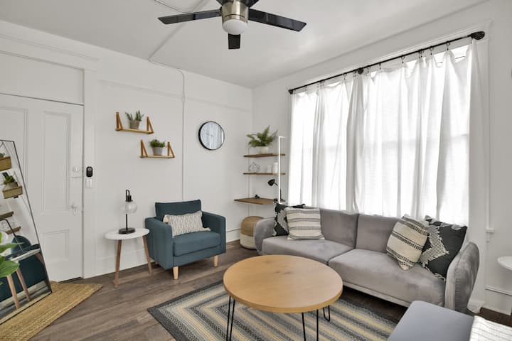 Main living area with the comfy sofa chair to cozy up with a coffee and a book and futon! There is also a small desk space and table and stools for two. 