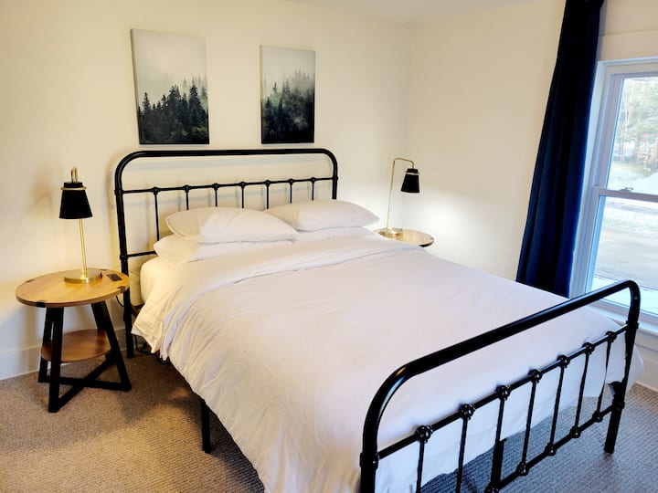 Third bedroom with queen bed, bedside tables with USB ports and lamps, plus room darkening curtains and a place to put your things away.