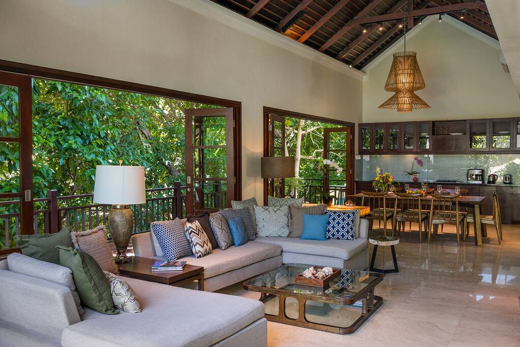 Comfortable sofa in spacious living room next to dining and kitchen