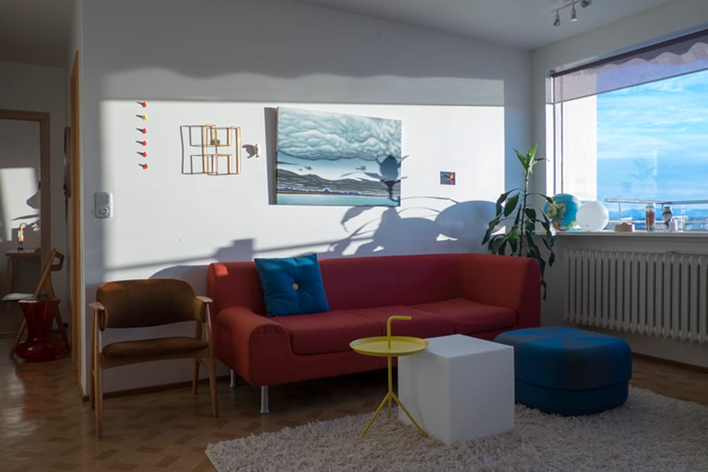 Comfy sofa and foot stool. Table and cube-lamp with a smart bulb.
