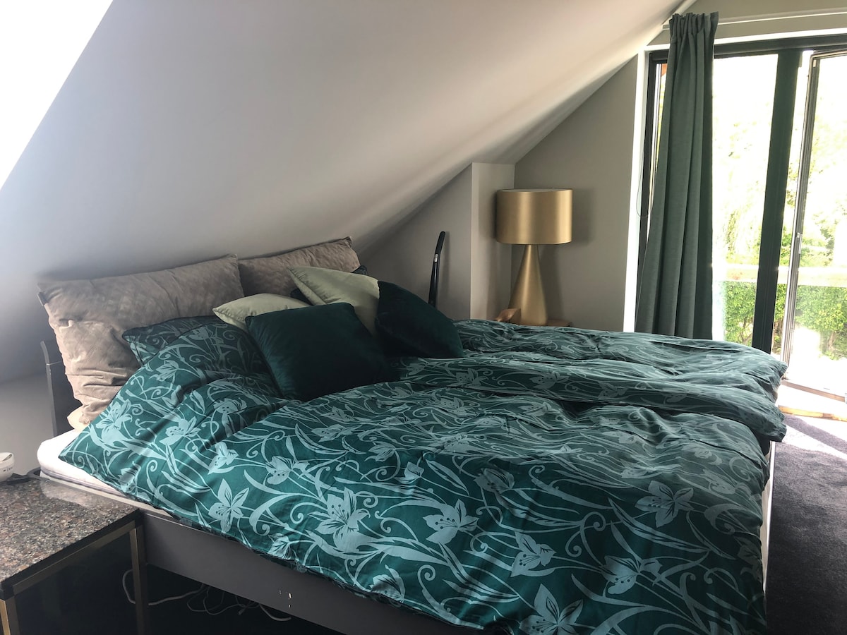 غرفة نوم رئيسية مع مكيف هواء وسرير كبير إضافي ومبرد. هناك أيضًا مساحة أرضية لمراتب إضافية إذا كان لديك أطفال قريبين. 