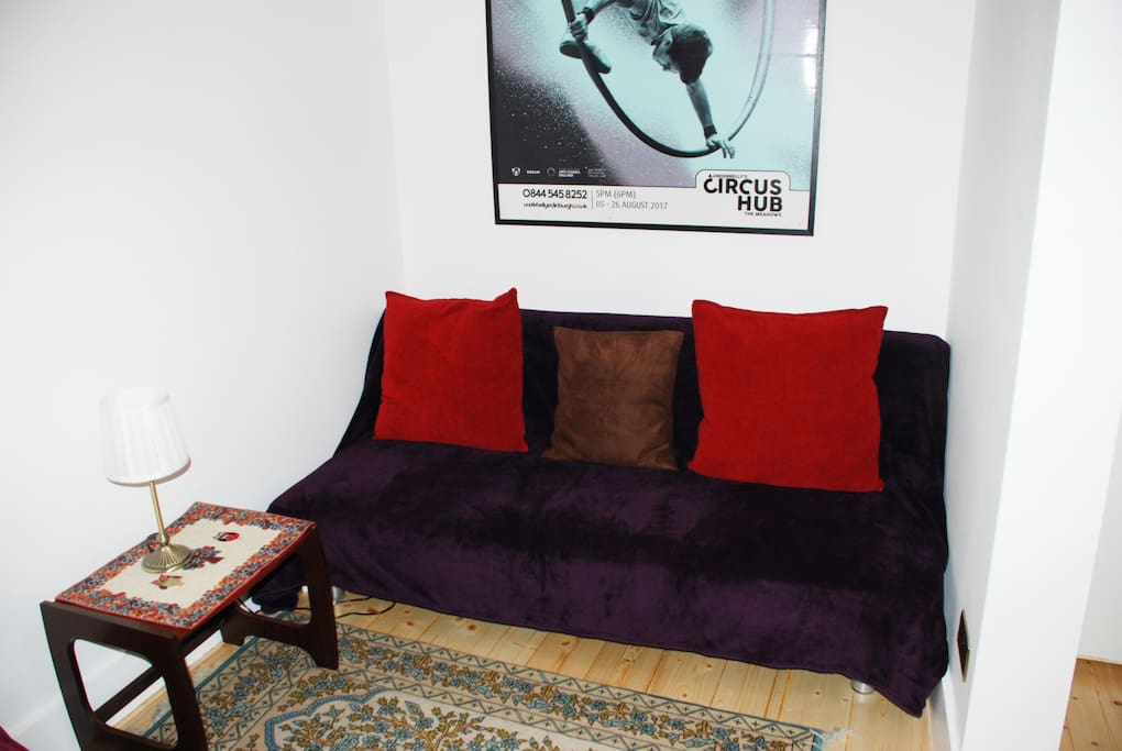 The living room sofa with an Edinburgh Festival poster above it