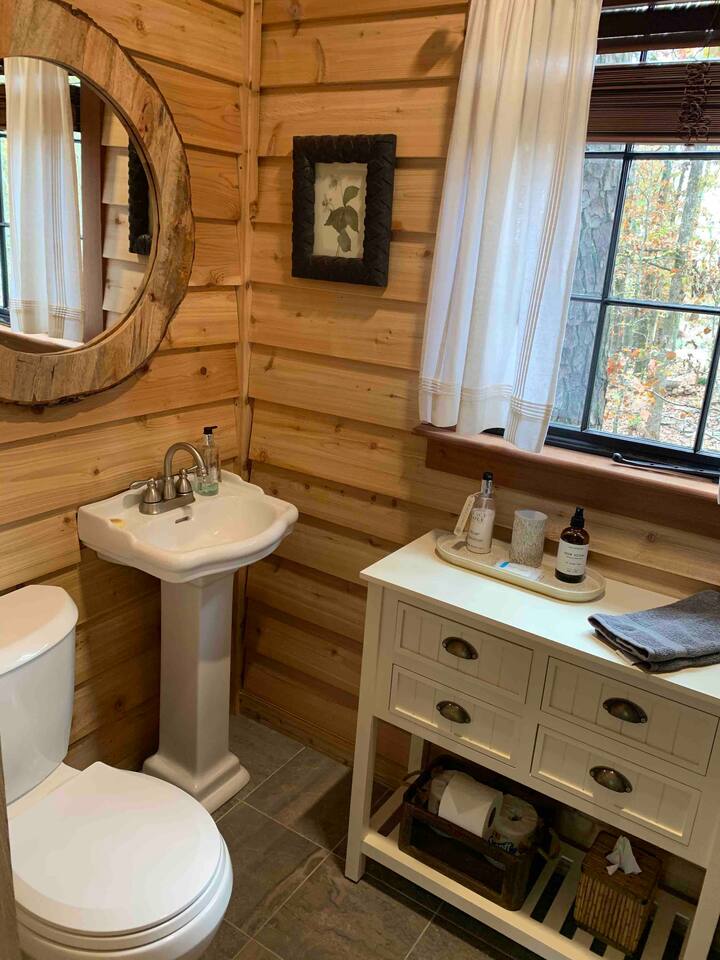 No compost toilets here! We want our guests to enjoy the conveniences they’re accustomed to — even in a treehouse! There are fresh towels, sundries often forgotten, nonstop hot water and a cheery window. Cedar siding ensures a fresh scent.