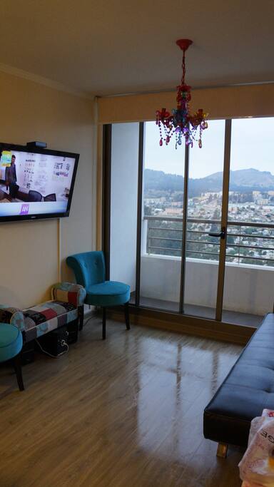 Living mas amplio en la foto con sus respectivas sillas y futon, hermosa vista a los cerros por lo demás.