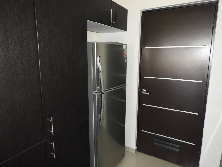 Refrigerador en cocina integral con barra y puerta hacia el cuarto de lavado