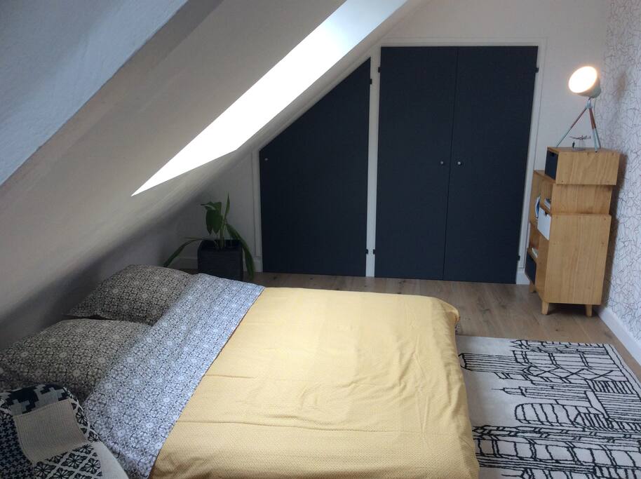 Chambre invités : lit double, penderie, meuble, fauteuil.