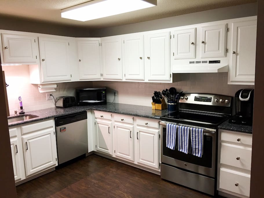 Modern, updated full kitchen with granite countertops, subway tile backsplash, brand new laminate flooring. Full size refrigerator is to the left of this photo.