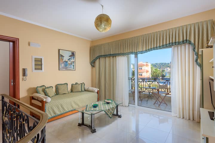 La sala de estar en el primer piso con un sofá cama para dos personas y un balcón.