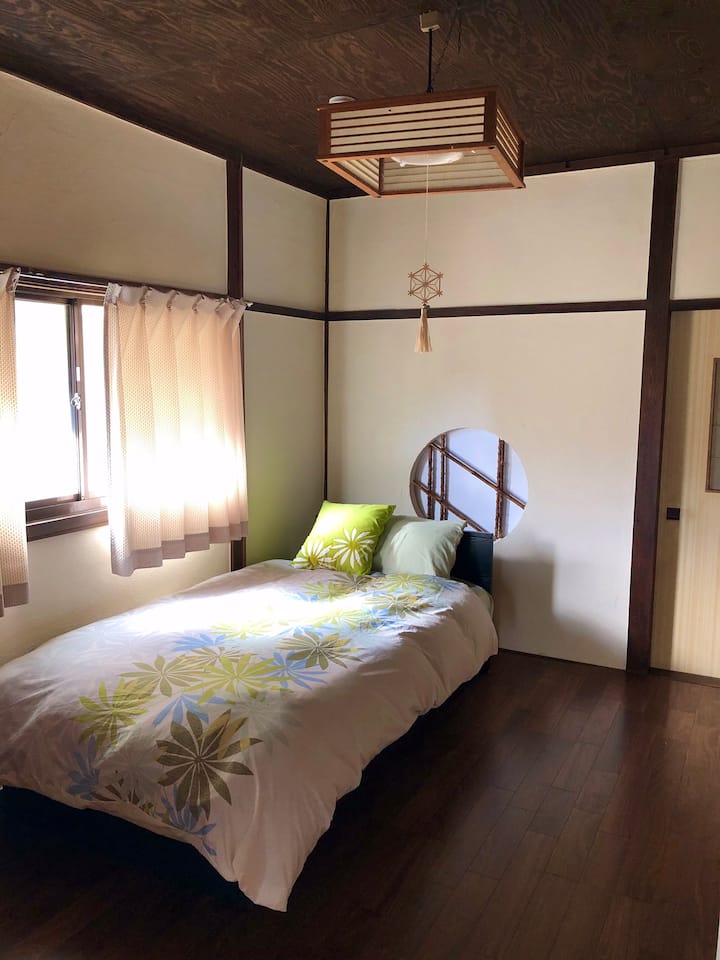 1階の和室ゲストルーム1（シングルベッド）。ミラー＆チェアー、クローゼットあり。エアコン完備