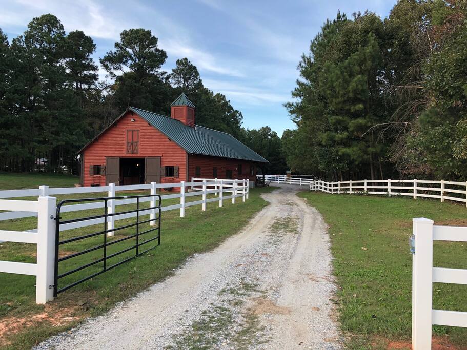 Gated driveway to barn with parking lot off front porch