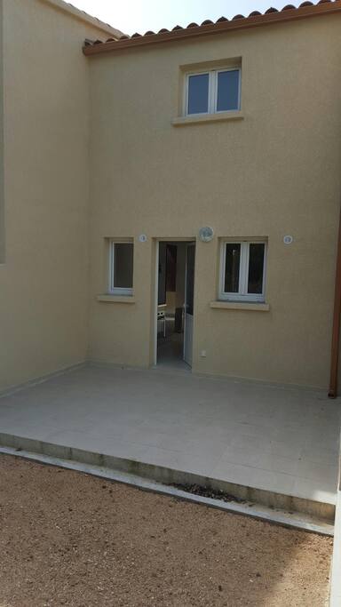 COTE OPPOSE SORTIE AVEC TERRASSE ET JARDINET AVEC TABLE CHAISE ET BARBECUE