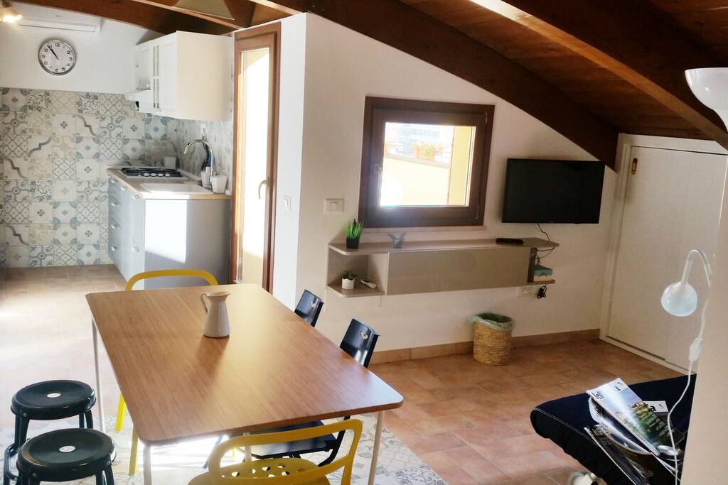 Soggiorno, zona pranzo con TV e cucina