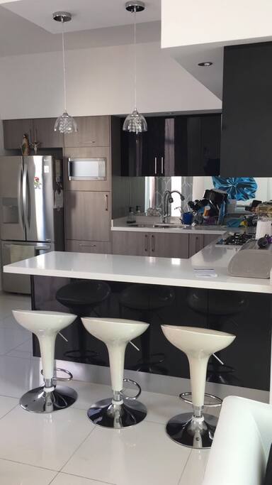 Cocina completamente equipada con utensilios y electrodomésticos barra de cuartzo y asientos para 5 personas