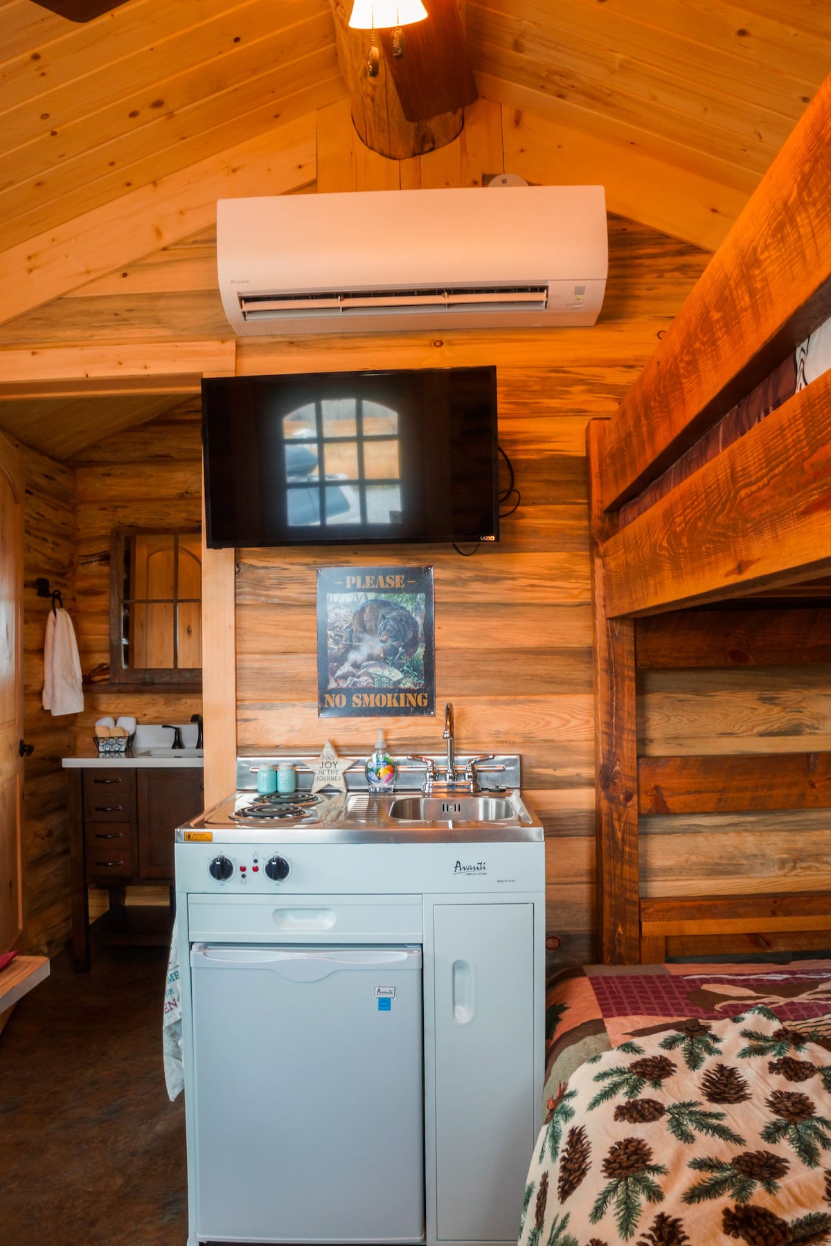 The kitchen (sink, 2- burner stove, 3.2 cu. ft. Refrigerator) satellite TV, heat pump/air conditioning, and bunk bed (twin over full/double) in the Bunkhouse Cabin. 