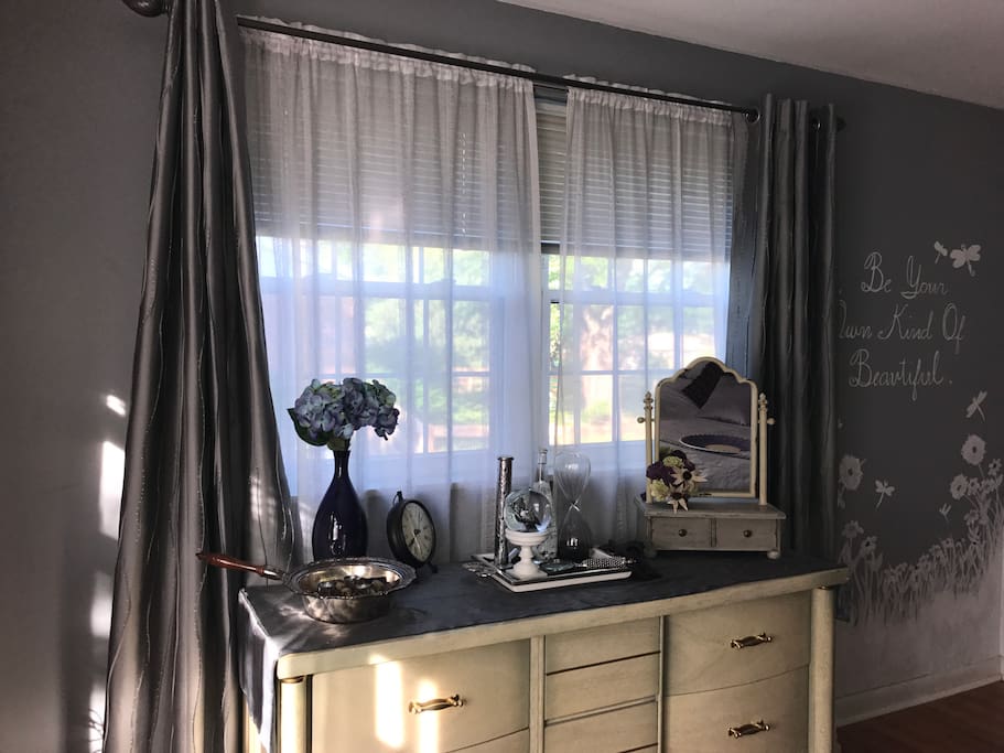 Be your own kind of beautiful! Gorgeous double window with curtains and blinds, framing a dresser for you to use.