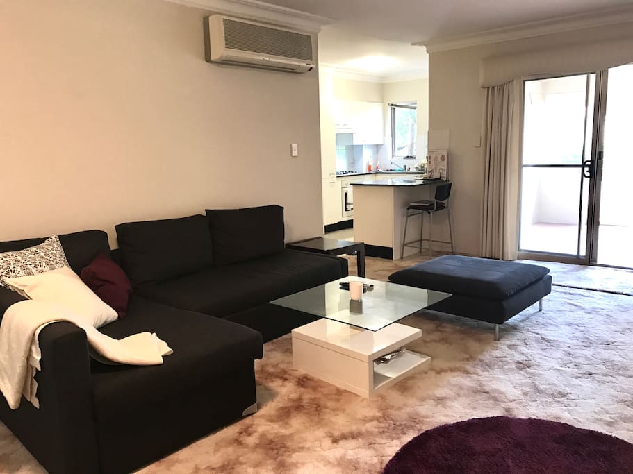 Lounge room looks out onto the sunroom, which provides ample natural light into the apartment.