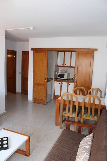 Vista general del salón, comedor, acceso al apartamento, cocina y cuarto de baño