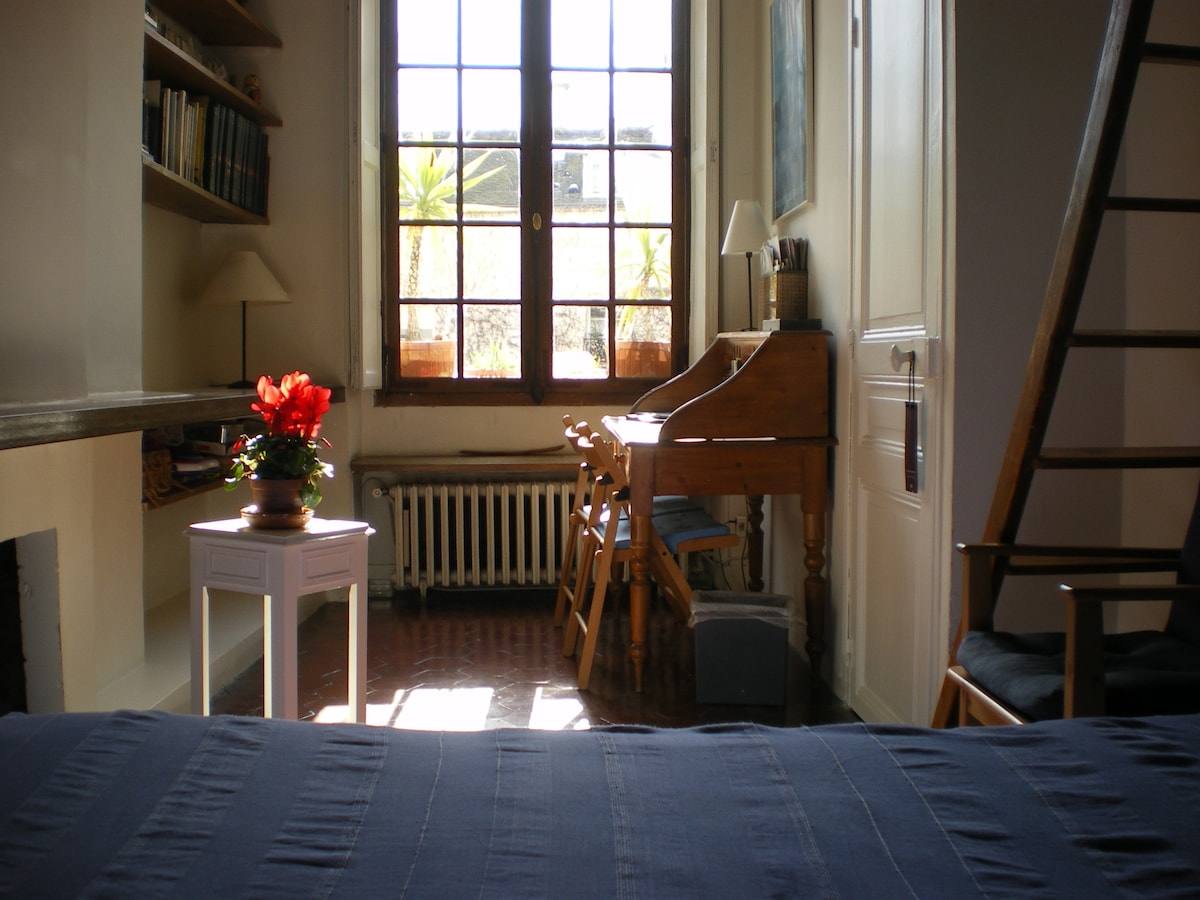 Radni stol i veliki prozor u mirnom vrtu.
