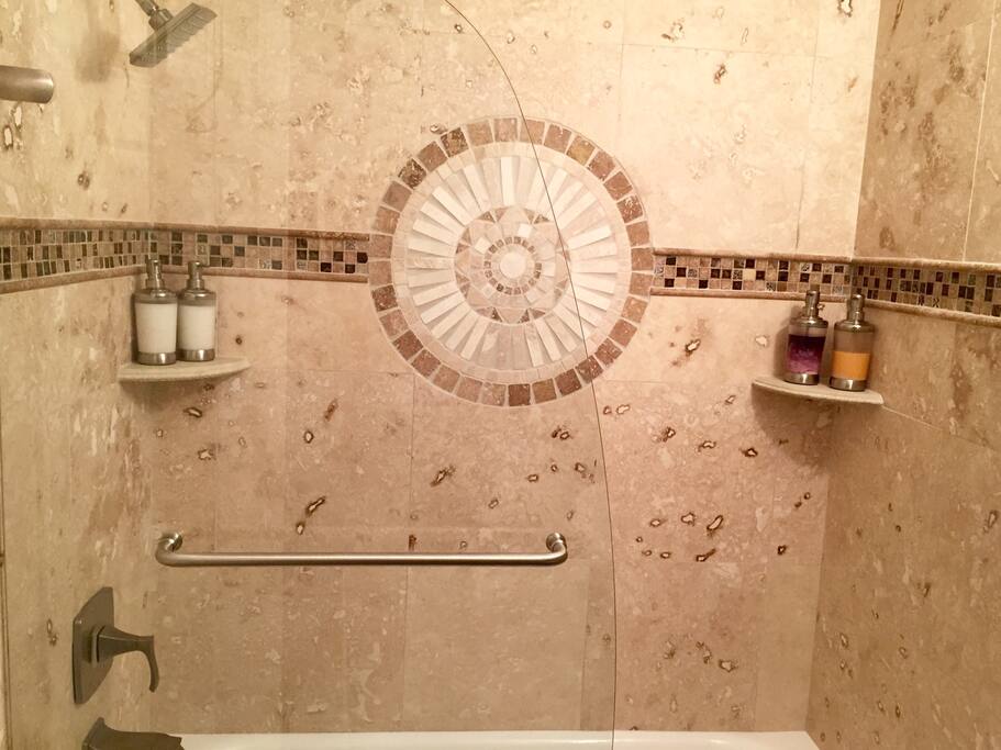 Travertine and frameless glass doors. Includes soaps