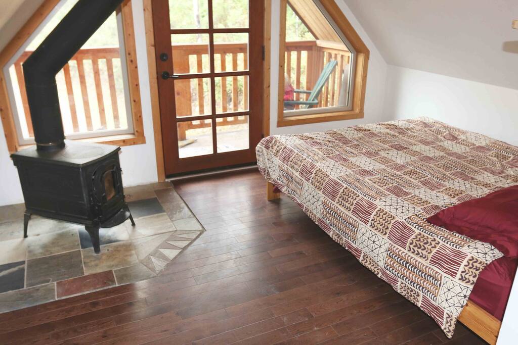 Cozy space with wood stove and large windows.