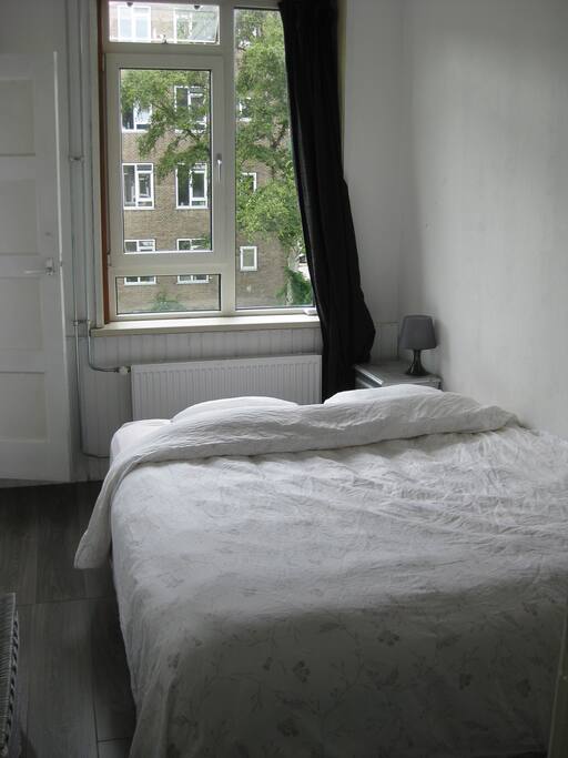 Slaapkamer met comfortabel tweepersoonsbed en een plankenkast voor kleding