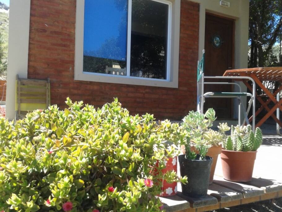Deck con mesa y silla de jardin, reposeras y espacio para descansar