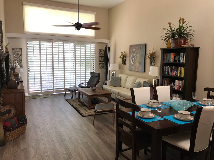 Comfortable living area with high ceilings, a ceiling fan and stocked bookcase