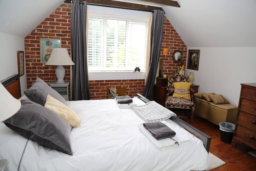 More exposed brick with pine floorboards in the main bedroom