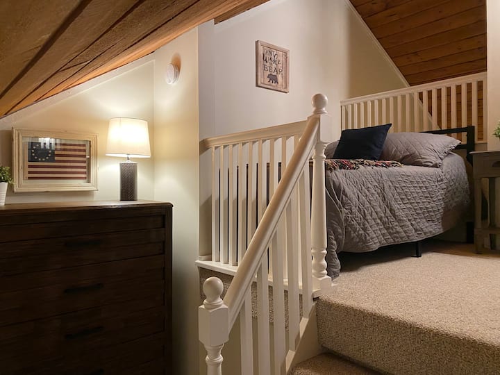 ห้องใต้หลังคามีเตียงขนาดใหญ่ที่มองเห็นห้องนั่งเล่น