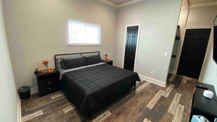 Master Bedroom yenye kitanda cha ukubwa wa King, runinga janja, bafu la kujitegemea, na ufikiaji wa moja kwa moja wa ukumbi wa nyuma.
