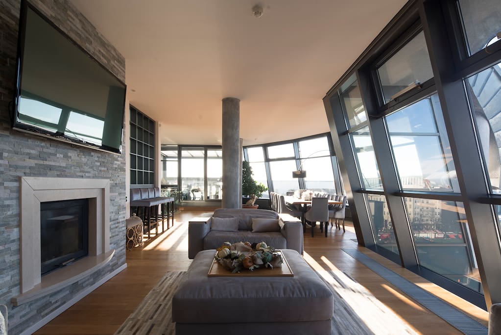 Living room and dining area, fire place with high ceilings, TV and terrace.