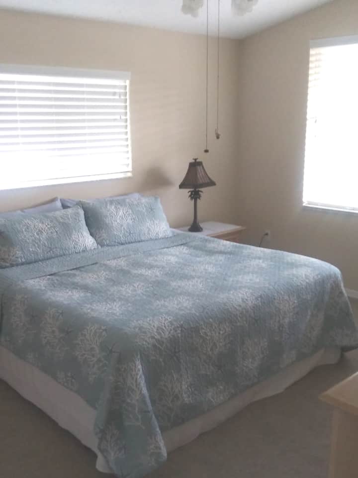 Hauptschlafzimmer mit Kingsize-Bett, großem Fenster mit Blick auf das Wasser