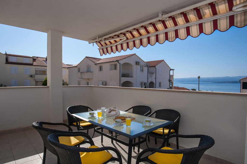 spacious terrace with dining table and sea&city view