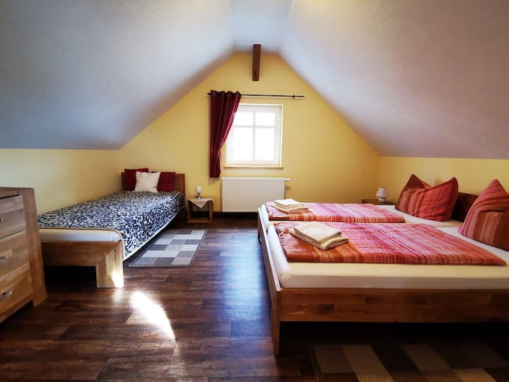Schlafzimmer mit einem Doppelbett und einem Einzelbett im Obergeschoss 
