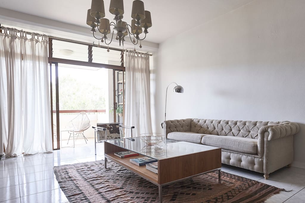 Lounge leading onto verandah looking at a beautiful garden below .